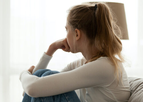 Photo of a depressed woman staring out the window