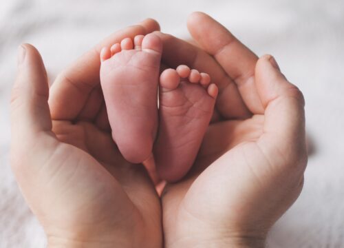 Photo of a woman's hands holding her baby's feet