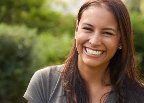 Photo of a smiling woman surrounded by greenery